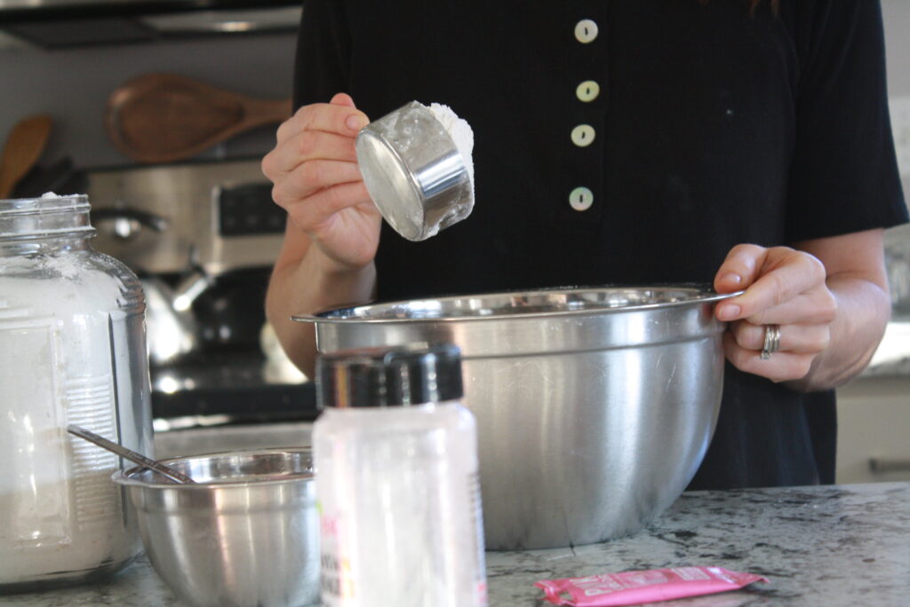 Woman at kitchen counter mixing the ingredients for this easy playdough recipe.