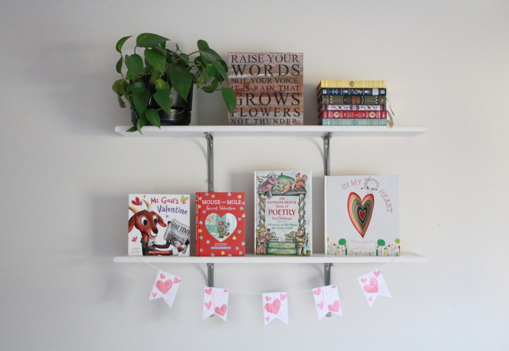 Bookshelves decorated with Valentine's Day banner and themed books perfect for Valentine's Day kid activities.