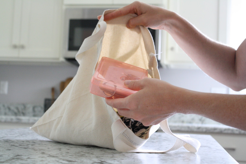 Woman in kitchen packing items into a church busy bag.