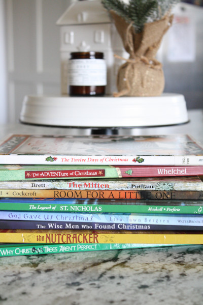 Stack of Christmas books for kids on kitchen counter.