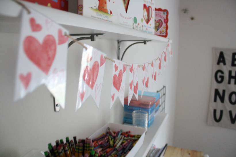 Free printable Valentine's Day banner completed and hanging on white shelf in homeschool room.