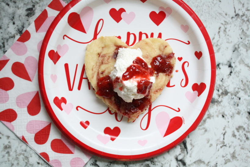 Heart-shaped strawberry swirl pancake on Valentine's Day plate for the perfect Valentine's Day breakfast for kids.