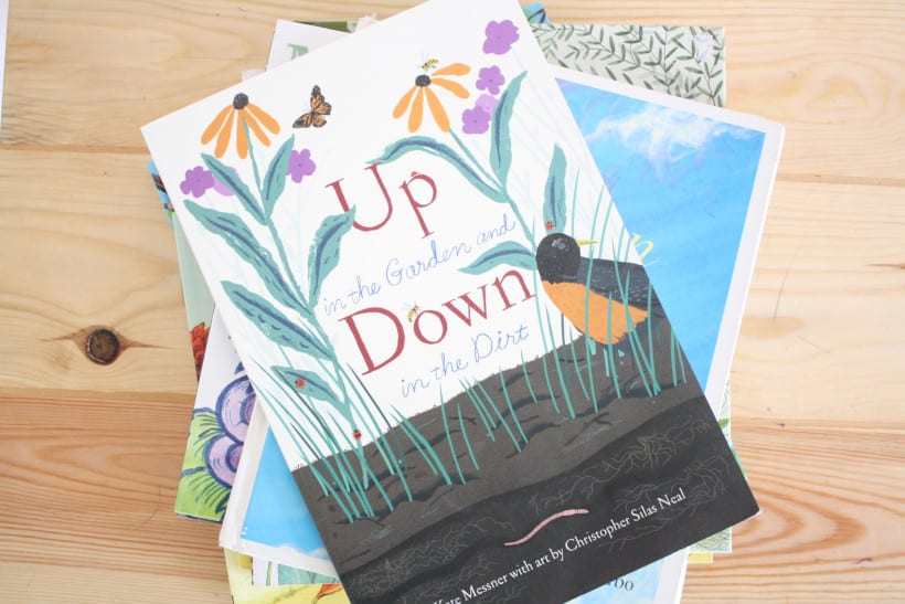 Stack of March picture books for kids on desk. Up in the Garden and Down in the Dirt displayed on top.