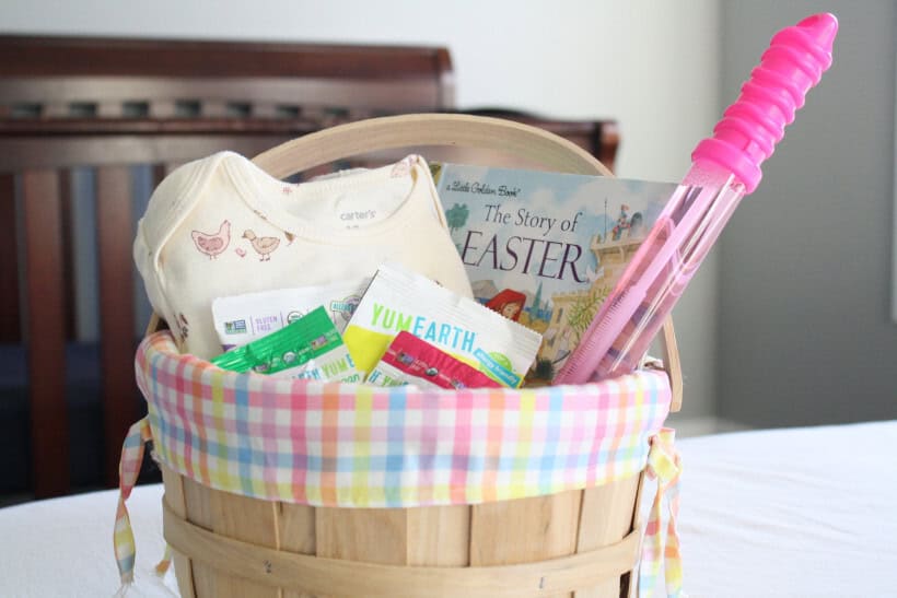 Colorful gingham Easter basket with clutter free gift ideas. Spring onesies, dye-free candies, book, and bubble wand.